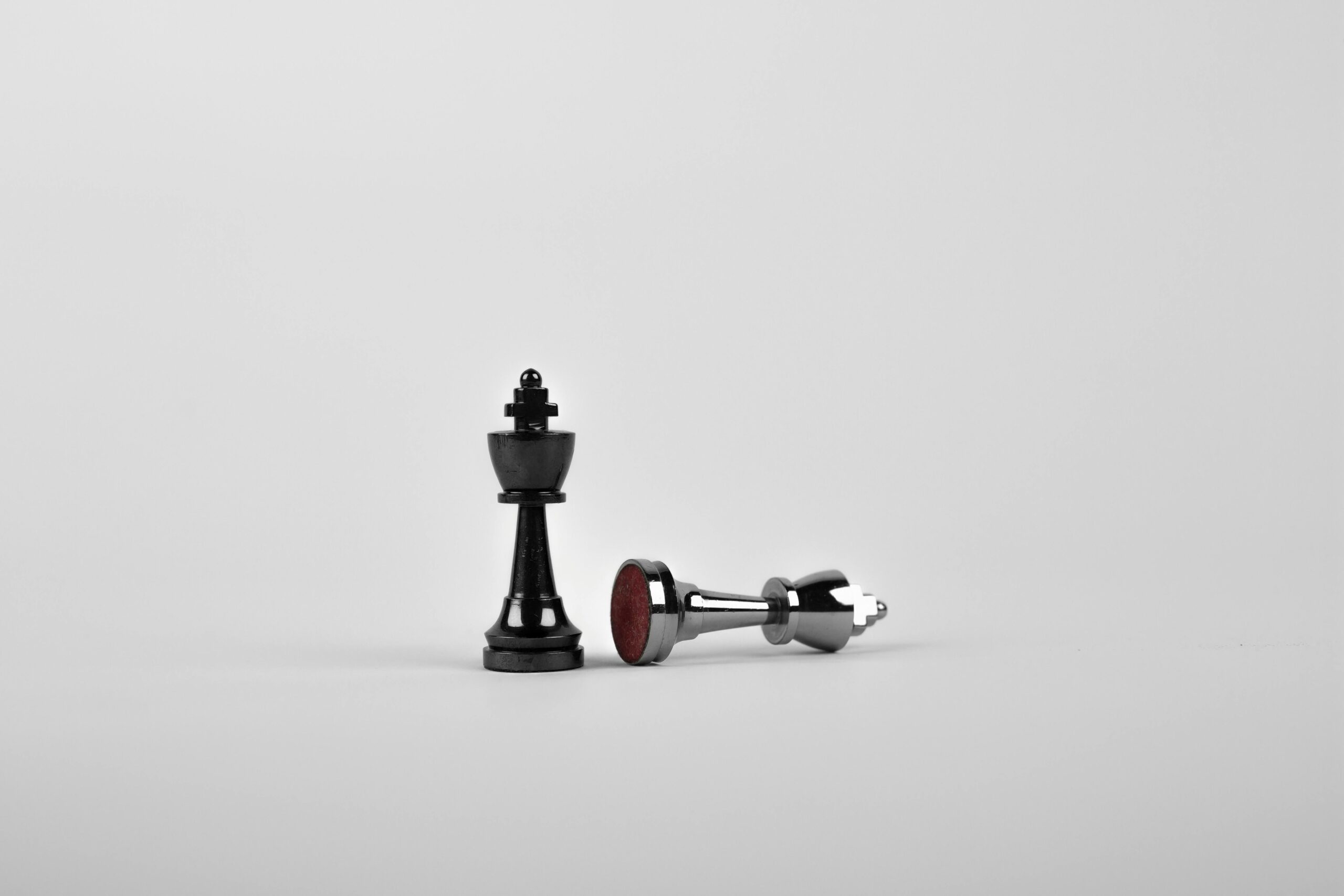 Is-marketing-sabotaging-your-success-article-image Close-up of chess king piece standing with a fallen piece symbolizing strategy and victory.